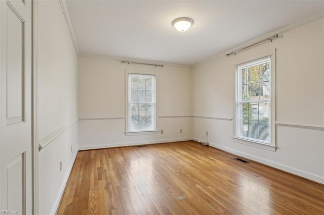 empty room with hardwood / wood-style floors and ornamental molding