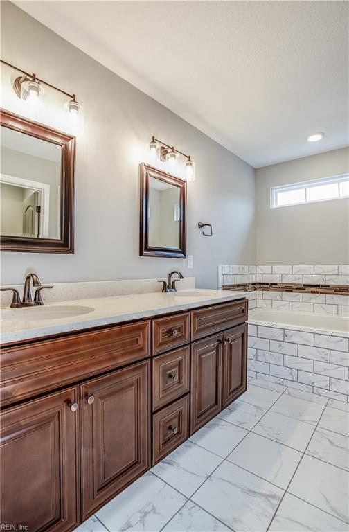 bathroom with a bathing tub and vanity