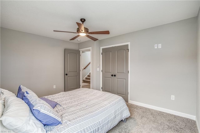 carpeted bedroom featuring a closet and ceiling fan