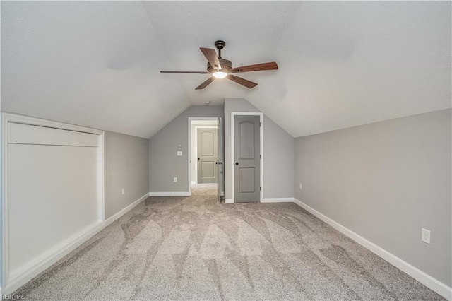 additional living space with vaulted ceiling, ceiling fan, and light carpet