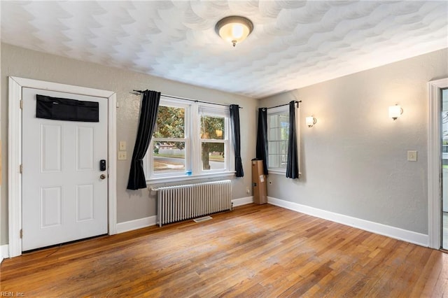 foyer featuring wood-type flooring and radiator