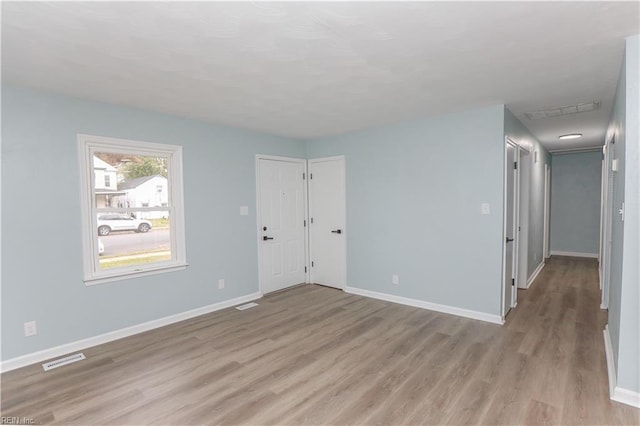 empty room with light hardwood / wood-style flooring