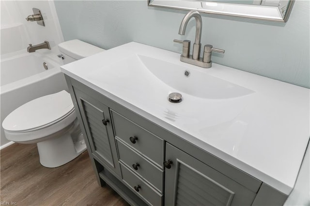 full bathroom featuring wood-type flooring, vanity, toilet, and bathtub / shower combination