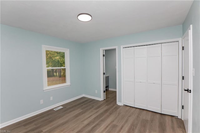 unfurnished bedroom with light wood-type flooring and a closet