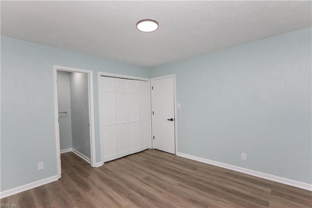 unfurnished bedroom featuring hardwood / wood-style floors and a closet