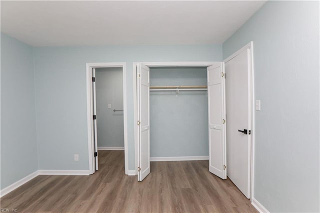 unfurnished bedroom with a closet and light wood-type flooring