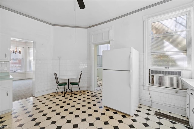 kitchen featuring crown molding, cooling unit, white fridge, white cabinets, and tile walls