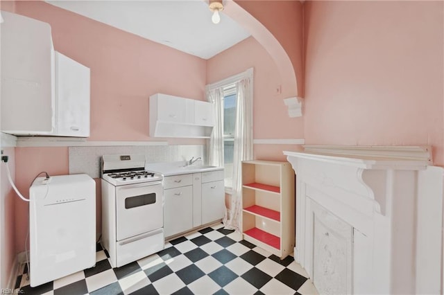 kitchen with tasteful backsplash, white cabinetry, and white stove