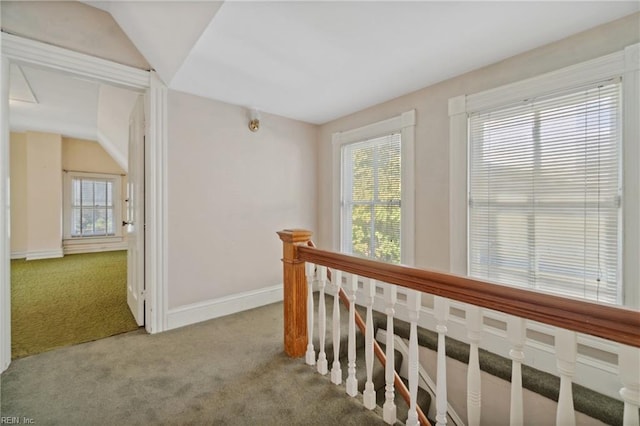 hall with carpet flooring and vaulted ceiling