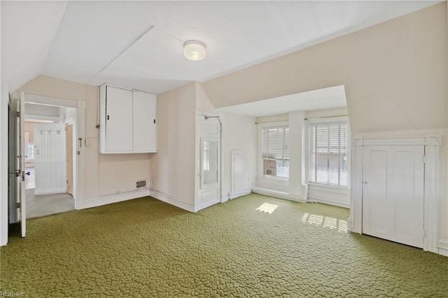 interior space featuring carpet floors and vaulted ceiling