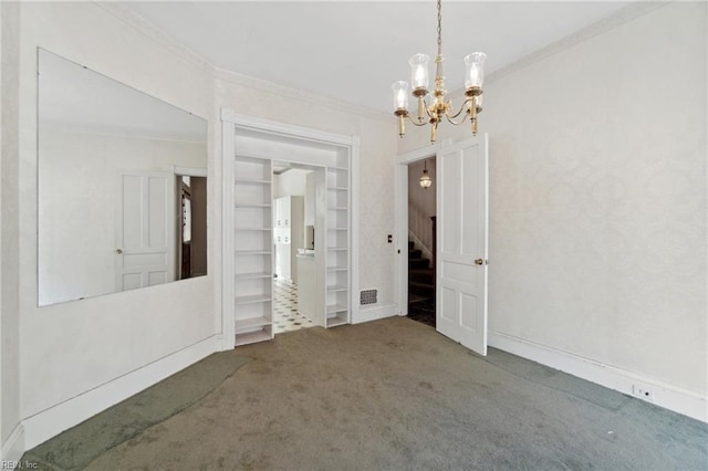 empty room with carpet floors, ornamental molding, and a notable chandelier