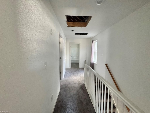 hall featuring dark colored carpet