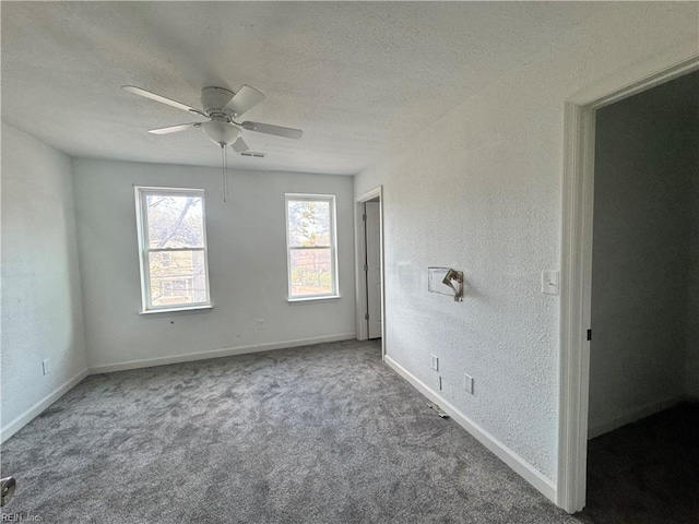 empty room featuring ceiling fan, a textured ceiling, and carpet flooring