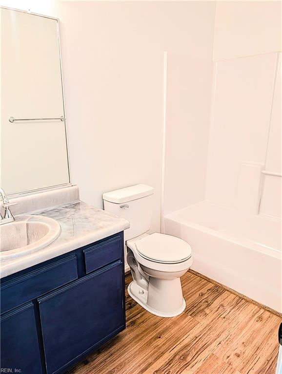 full bathroom featuring vanity, toilet, wood-type flooring, and bathing tub / shower combination