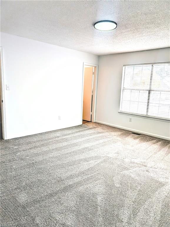 unfurnished room with a textured ceiling and carpet floors