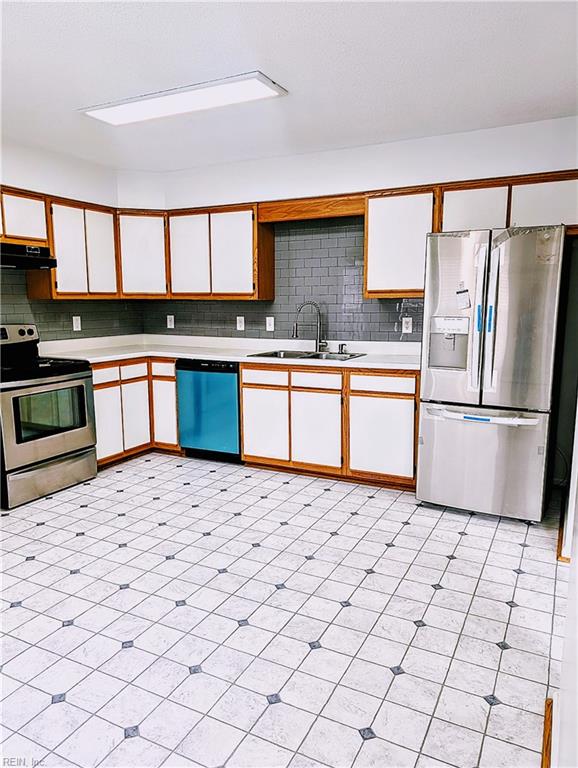 kitchen featuring appliances with stainless steel finishes, backsplash, white cabinetry, and sink