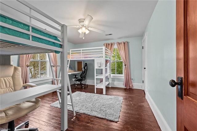 bedroom with ceiling fan, multiple windows, and dark hardwood / wood-style flooring