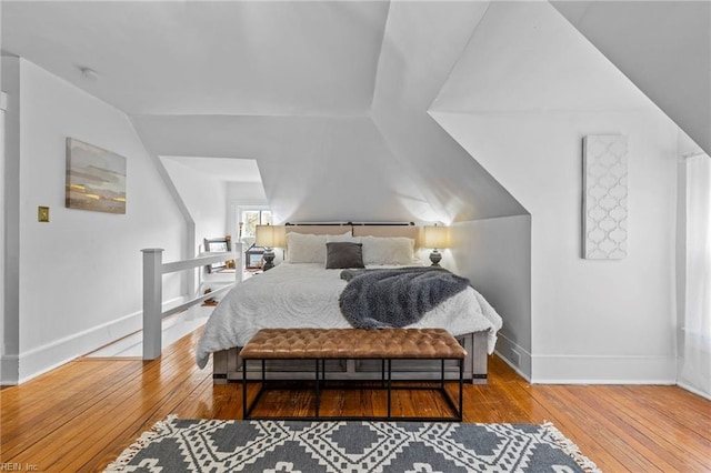 bedroom featuring hardwood / wood-style floors and vaulted ceiling