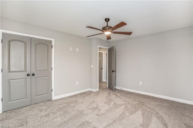 unfurnished bedroom featuring a closet, ceiling fan, and light carpet