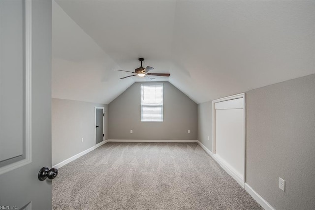 bonus room with vaulted ceiling, ceiling fan, and light colored carpet