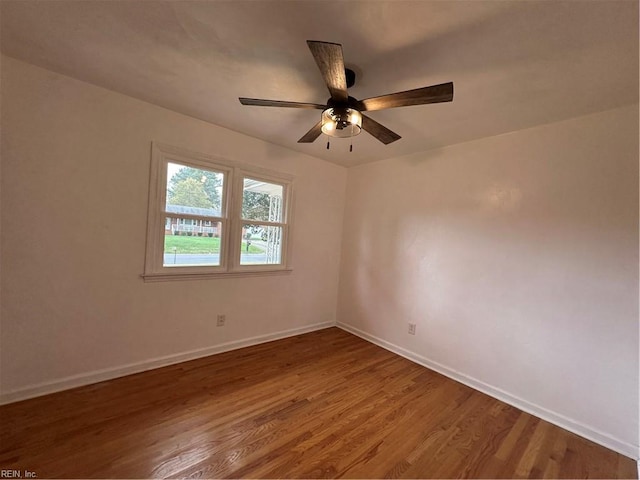 empty room with baseboards, ceiling fan, and wood finished floors