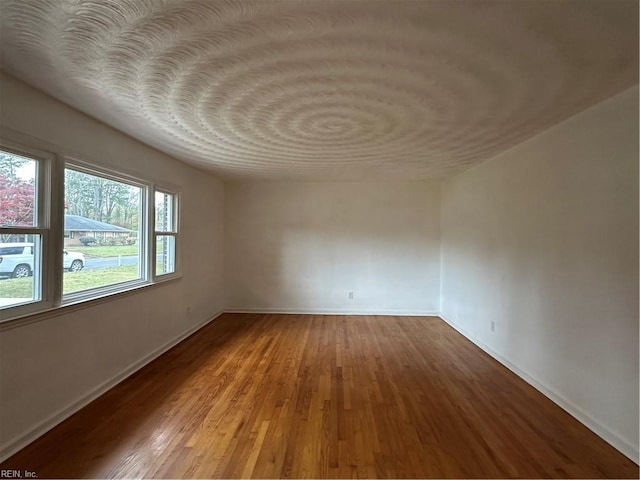 unfurnished room featuring baseboards and wood finished floors