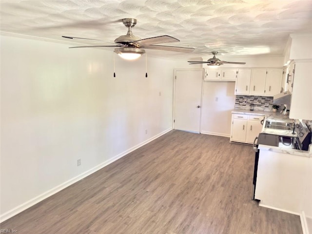 kitchen featuring white cabinets, light countertops, a ceiling fan, wood finished floors, and backsplash