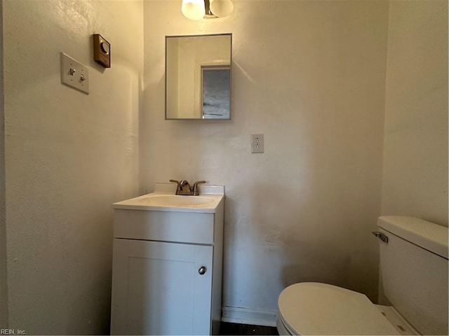 half bath featuring toilet and vanity
