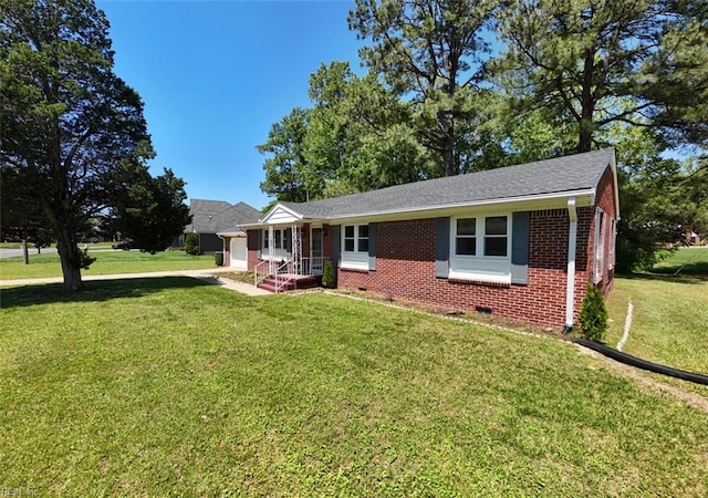 single story home featuring a shingled roof, an attached garage, brick siding, a front yard, and crawl space