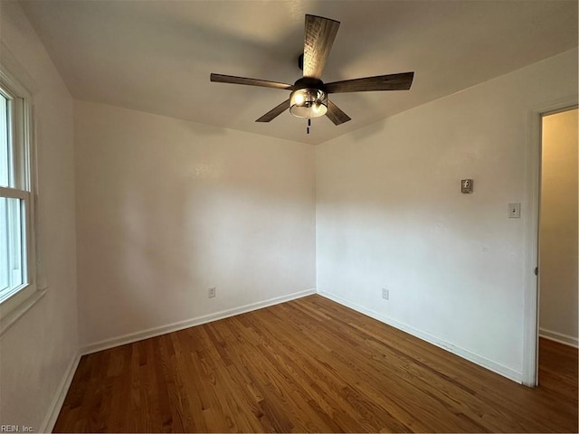 unfurnished room featuring baseboards, ceiling fan, and wood finished floors