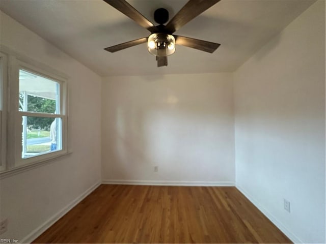 empty room with a ceiling fan, baseboards, and wood finished floors