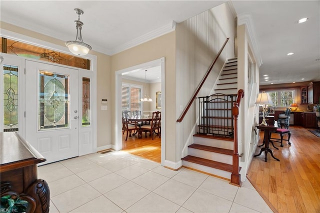 foyer entrance featuring a chandelier, light hardwood / wood-style floors, and ornamental molding