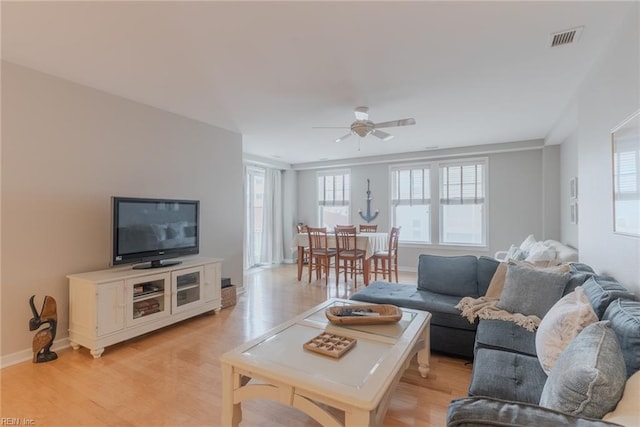 living room with light hardwood / wood-style floors and ceiling fan