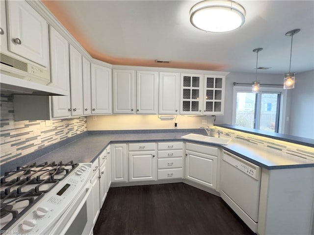 kitchen featuring white appliances, white cabinets, hanging light fixtures, and sink