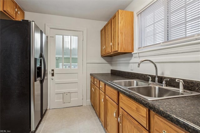 kitchen with stainless steel fridge, light tile patterned floors, and sink