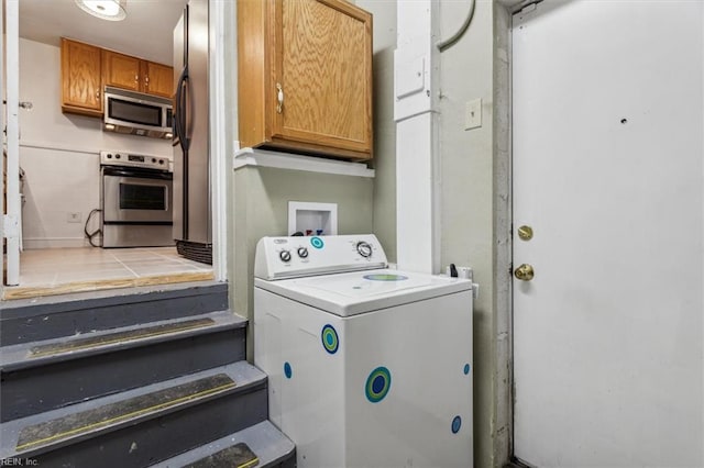 washroom with washer / clothes dryer and cabinets