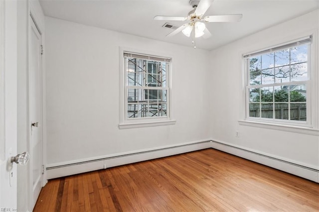 empty room with ceiling fan and light hardwood / wood-style flooring