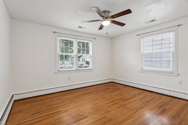 empty room with light hardwood / wood-style floors, ceiling fan, and a baseboard heating unit