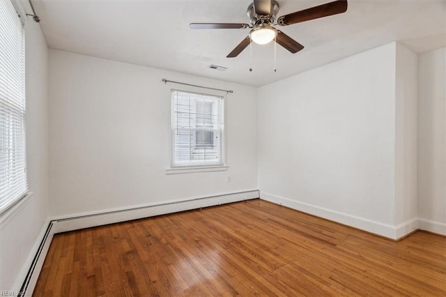 empty room featuring hardwood / wood-style floors, ceiling fan, and baseboard heating