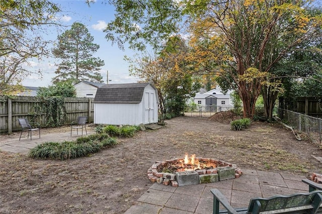 view of yard featuring a patio area, a fire pit, and a storage unit