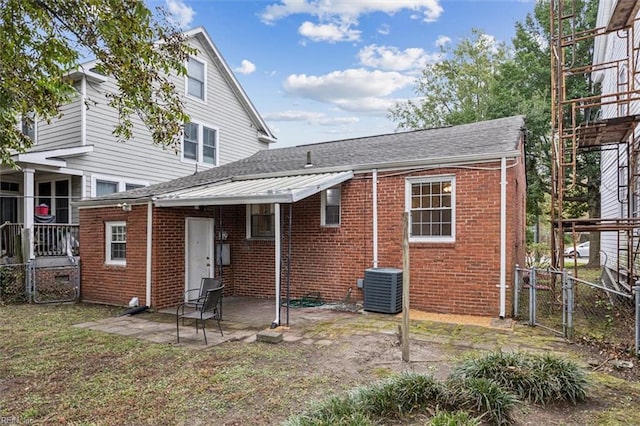 back of property with central AC unit and a patio area