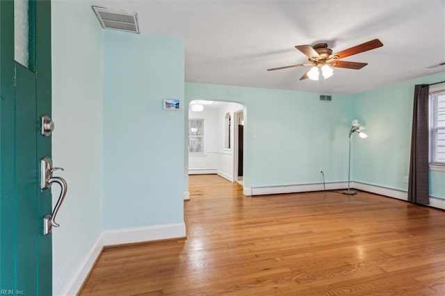 unfurnished room with light hardwood / wood-style flooring, ceiling fan, and a baseboard heating unit