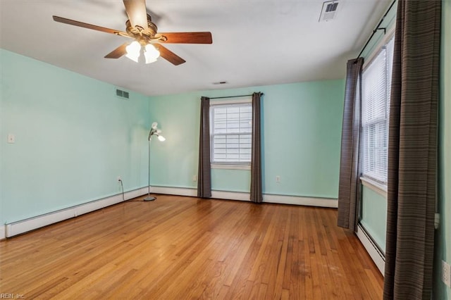 unfurnished room featuring ceiling fan, light hardwood / wood-style flooring, and a baseboard heating unit