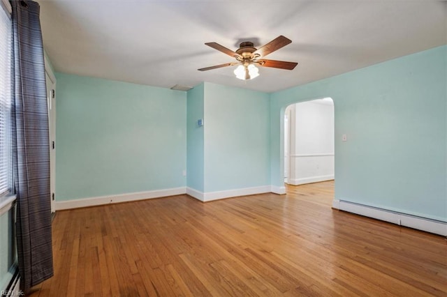 spare room with ceiling fan, light hardwood / wood-style flooring, and a baseboard heating unit