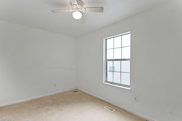 carpeted spare room featuring ceiling fan