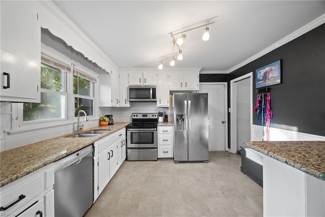 kitchen featuring dark stone counters, stainless steel appliances, crown molding, sink, and white cabinets