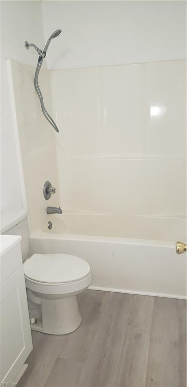 full bathroom with shower / washtub combination, hardwood / wood-style flooring, toilet, and vanity