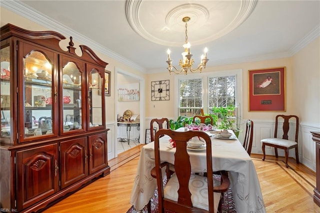 dining room featuring light hardwood / wood-style floors, crown molding, and a chandelier