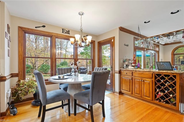 dining room with a chandelier, sink, and light hardwood / wood-style flooring