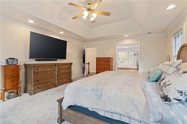 carpeted bedroom with ceiling fan, ornamental molding, and a tray ceiling